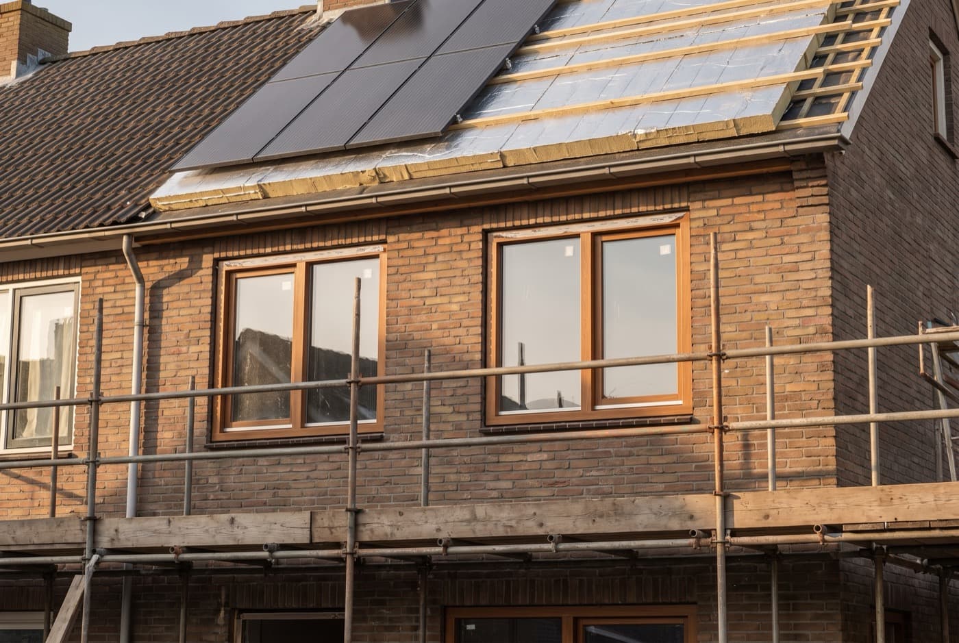 Woning met zonnepanelen op het dak tijdens een renovatie